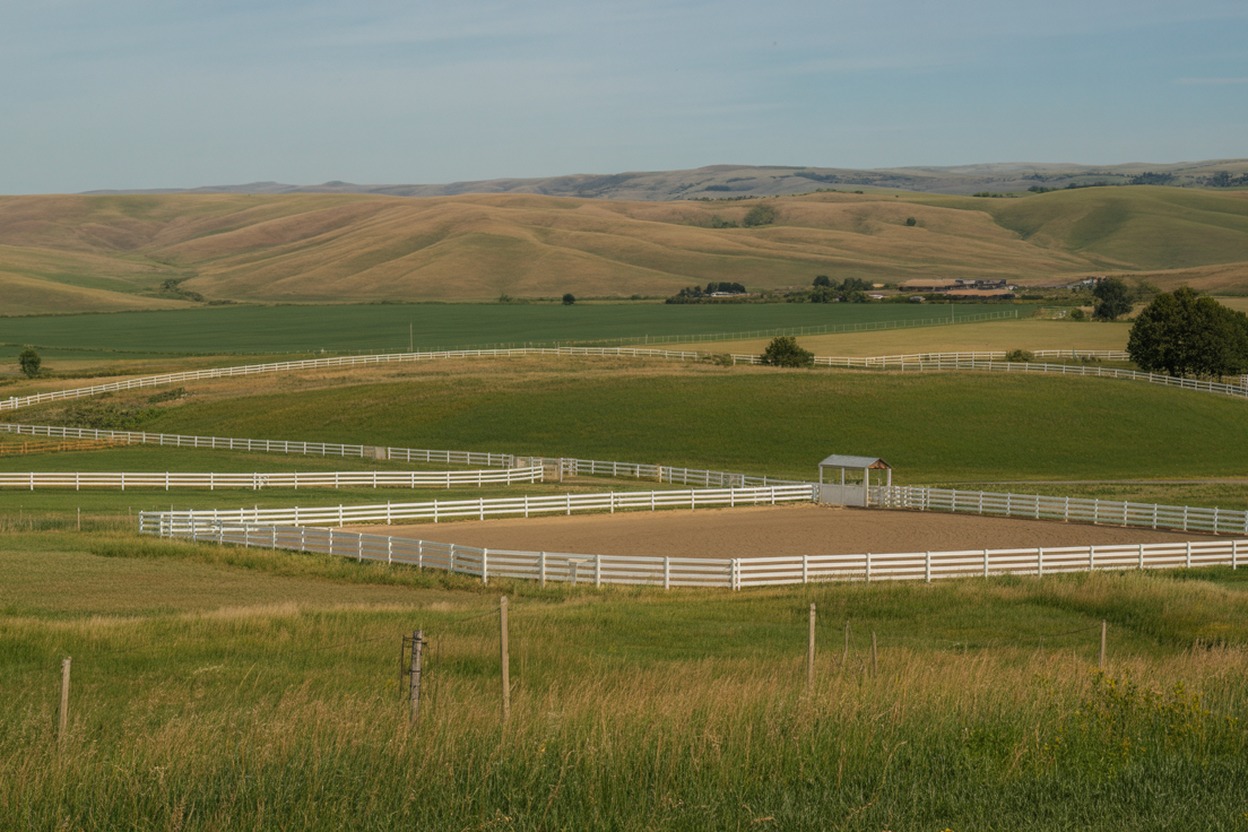 Equestrian property with white fencing, green pastures, and riding arena in the Idaho-Oregon Treasure Valley